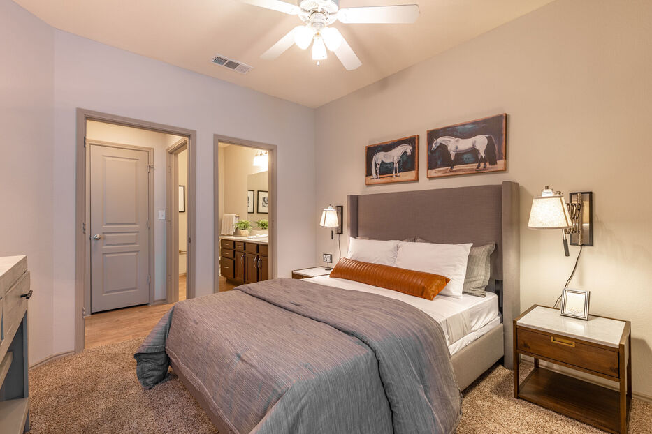 a bedroom with a bed, dresser and ceiling fan at The  Wyatt at Presidio Junction