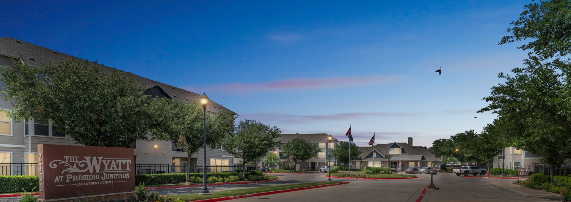 the entrance to a residential community at night at The Wyatt at Presidio Junction