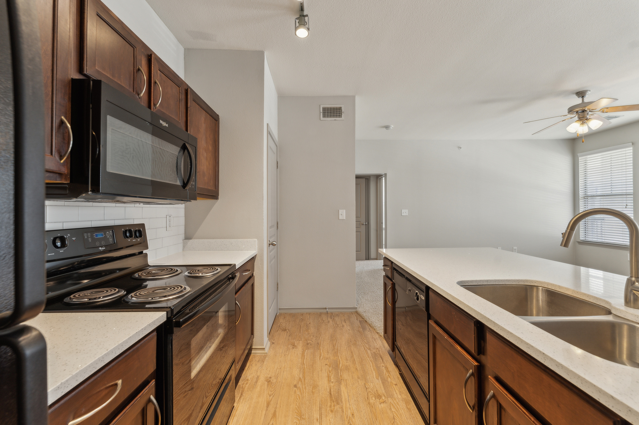 a kitchen with stainless steel appliances and wood cabinets at The  Wyatt at Presidio Junction