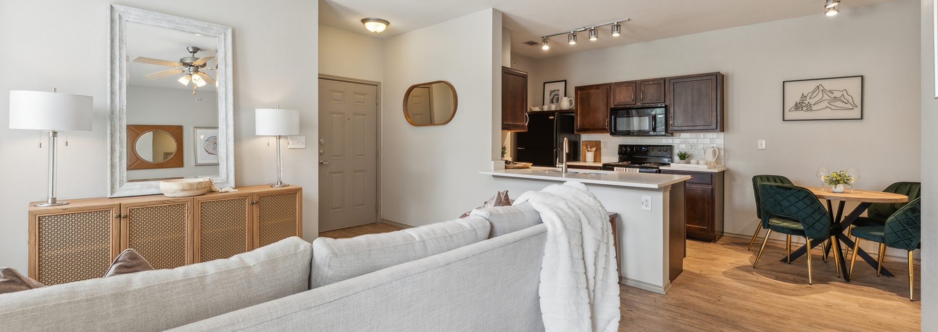 a living room and kitchen area with a ceiling fan at The Wyatt at Presidio Junction