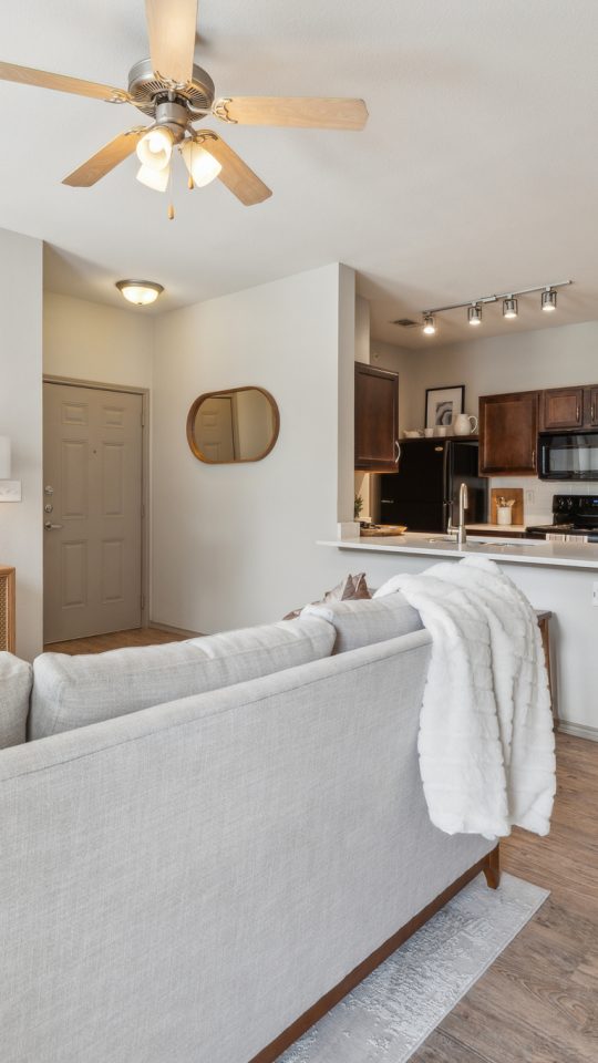 a living room and kitchen area with a ceiling fan at The Wyatt at Presidio Junction