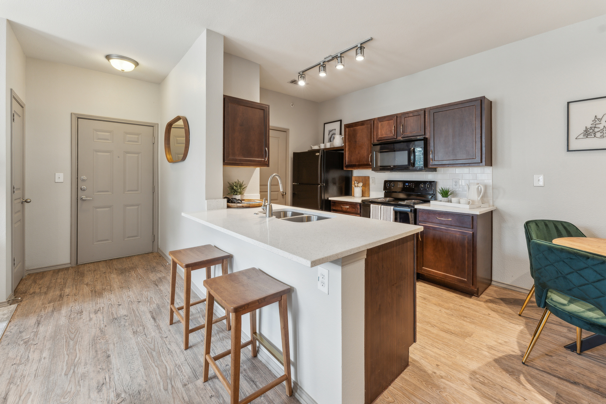 the kitchen and dining area of a home with wood floors at The  Wyatt at Presidio Junction