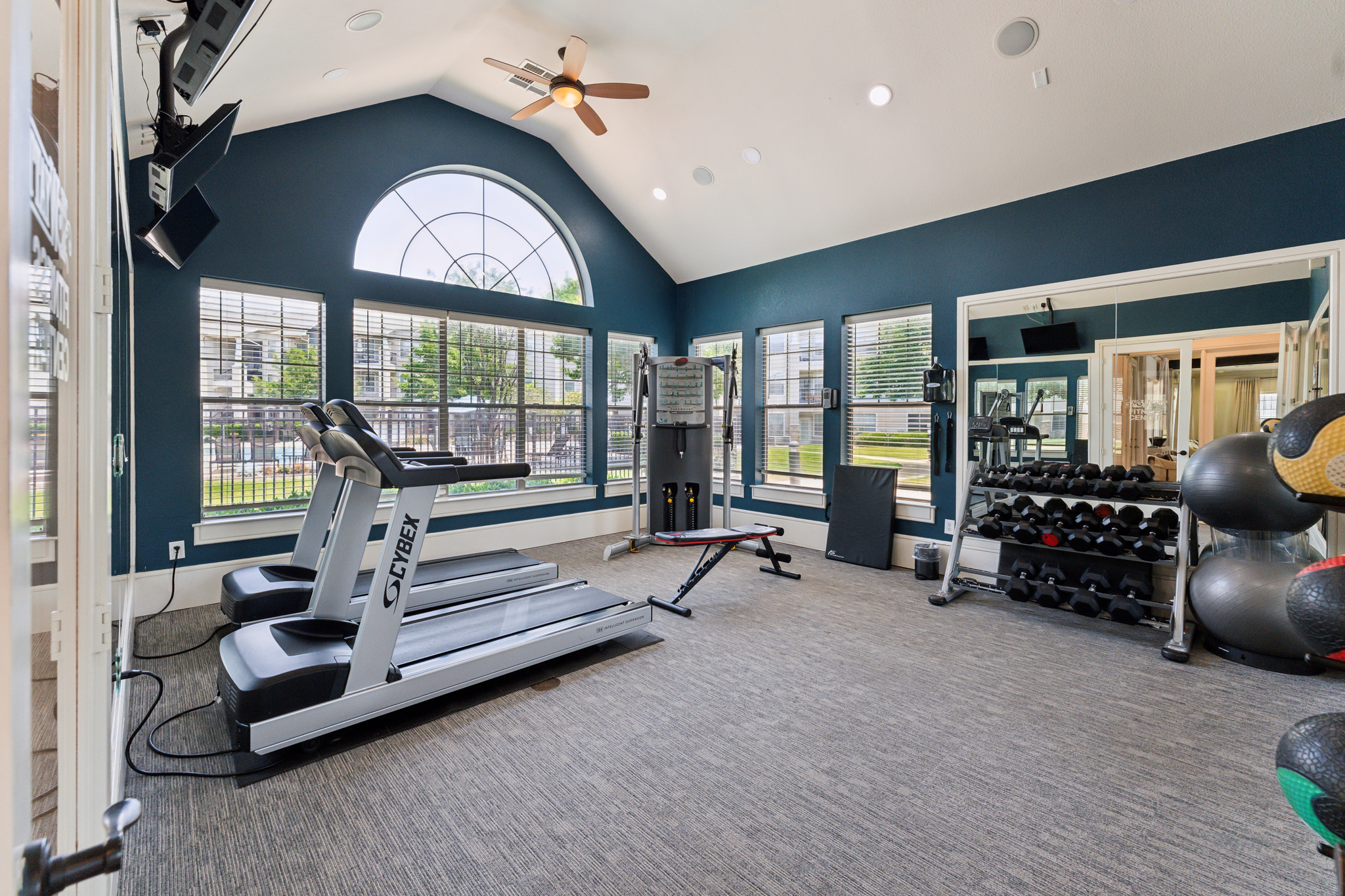a gym room with a treadmill, weights and other equipment at The  Wyatt at Presidio Junction